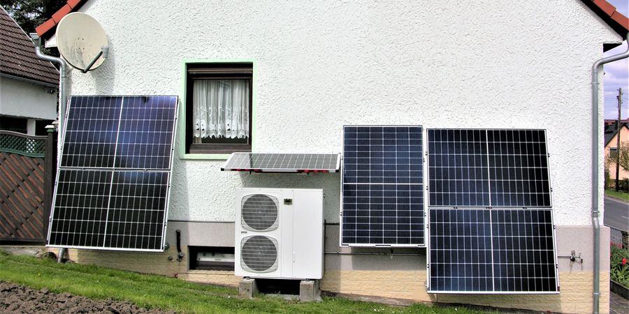 Wärmepumpe und Photovoltaik vor einem Einfamilienhaus.