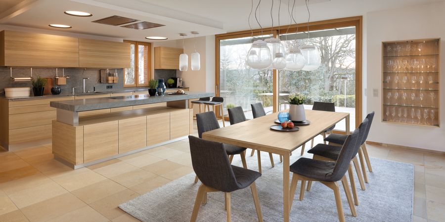 Moderne Wohnküche mit Holzfronten aus viel Stauraum in Schränken.