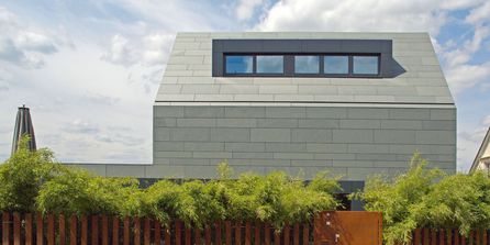 Moderne Natursteinfassade in hellem Grau.