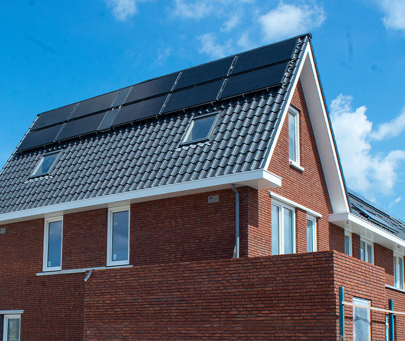 Foto: Seitenansicht eines Hauses mit Wärmepumpe mit Photovoltaik von Triple Solar.