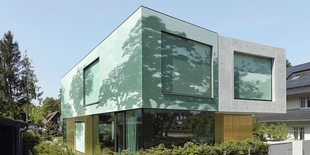 Bild: Es wird der textile Sonnenschutz von WAREMA gezeigt. Die Silhouette des Baumes wird auf der Gebäudefassade imitiert.